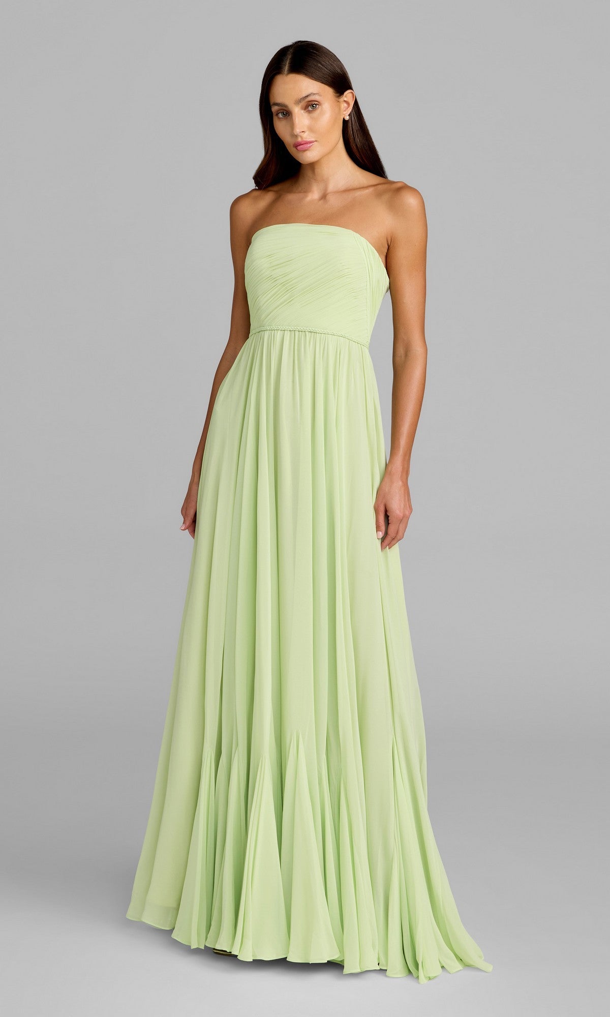 A woman poses against a plain gray background wearing the Mac Duggal 68847 Long Formal Dress in mint, featuring a strapless fitted bodice and a loose, flowing A-line chiffon skirt.